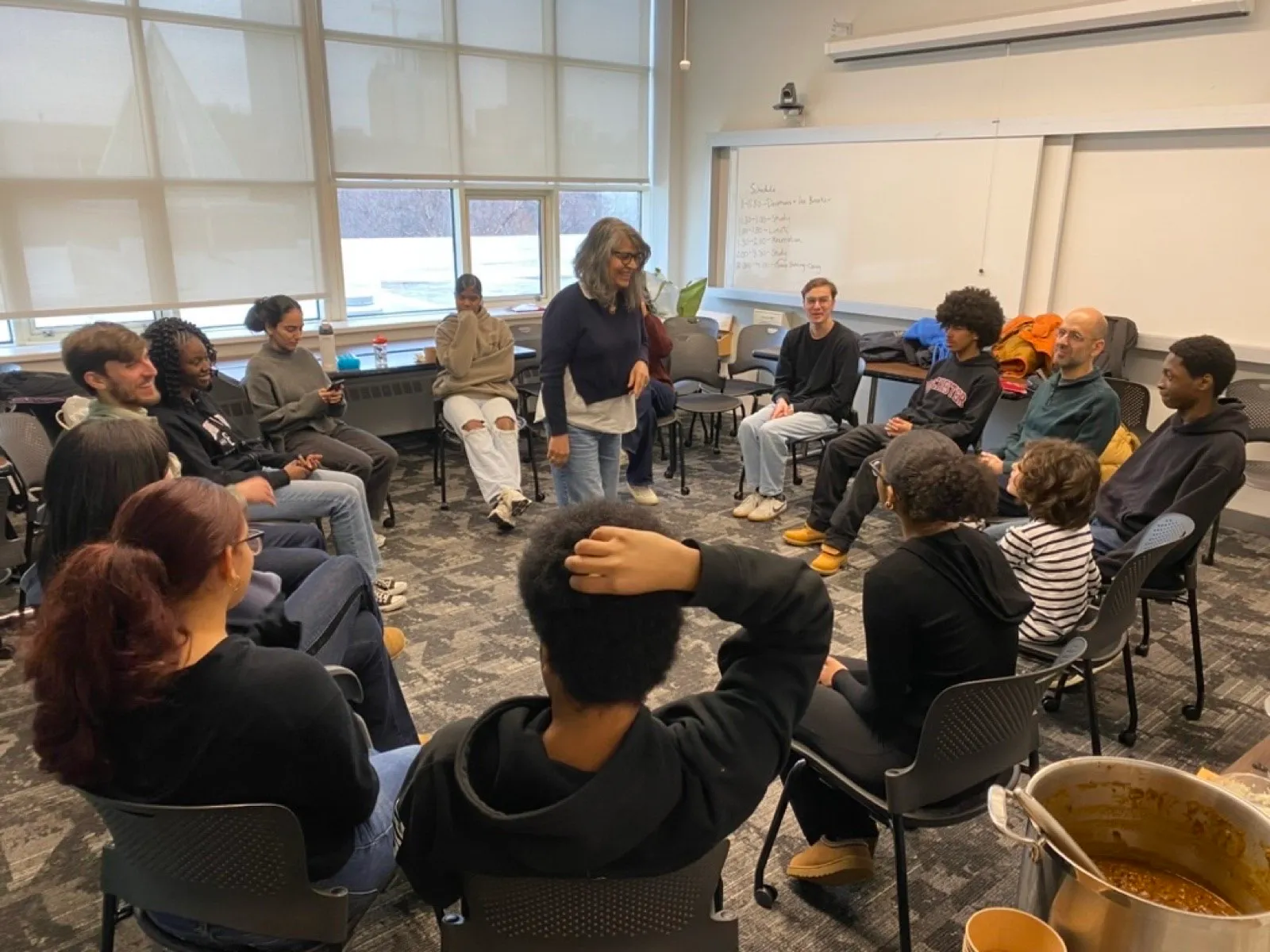 A discussion circle of young adults seated together, mid-conversation